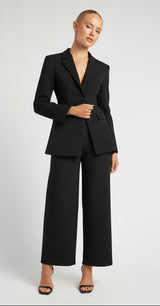 Woman wearing a white suit on a plain background