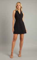 Woman wearing a black sleeveless dress with buttons on a white background