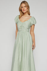 Woman wearing a light green dress on a plain background