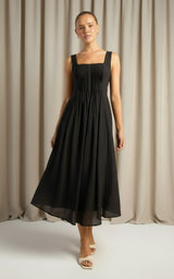 Woman wearing a black sleeveless dress on a white background